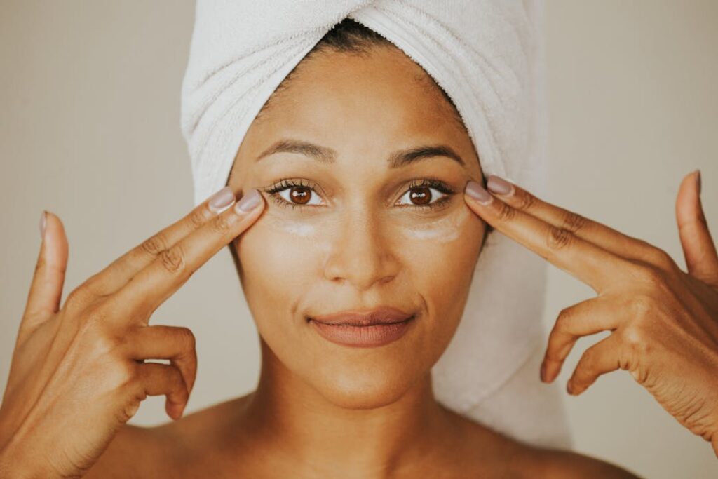 woman touching her face, how to even skin tone